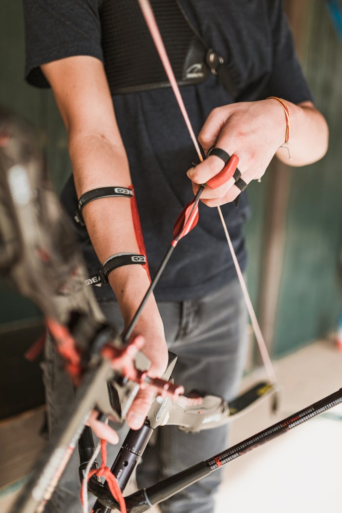 Focused archer setting an arrow in a compound bow.